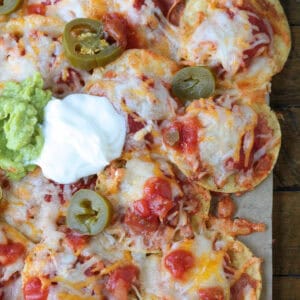 nachos with toppings on parchment paper