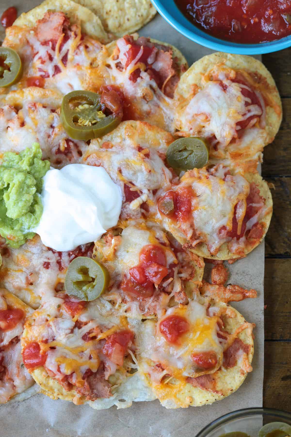 nachos with toppings on parchment paper