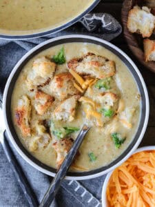 broccoli cheese soup in bowl with spoon and croutons