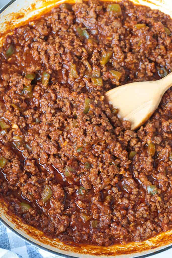 sloppy joe meat in a skillet with wooden spoon