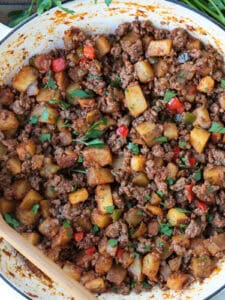 ground beef with potatoes and peppers in a skillet