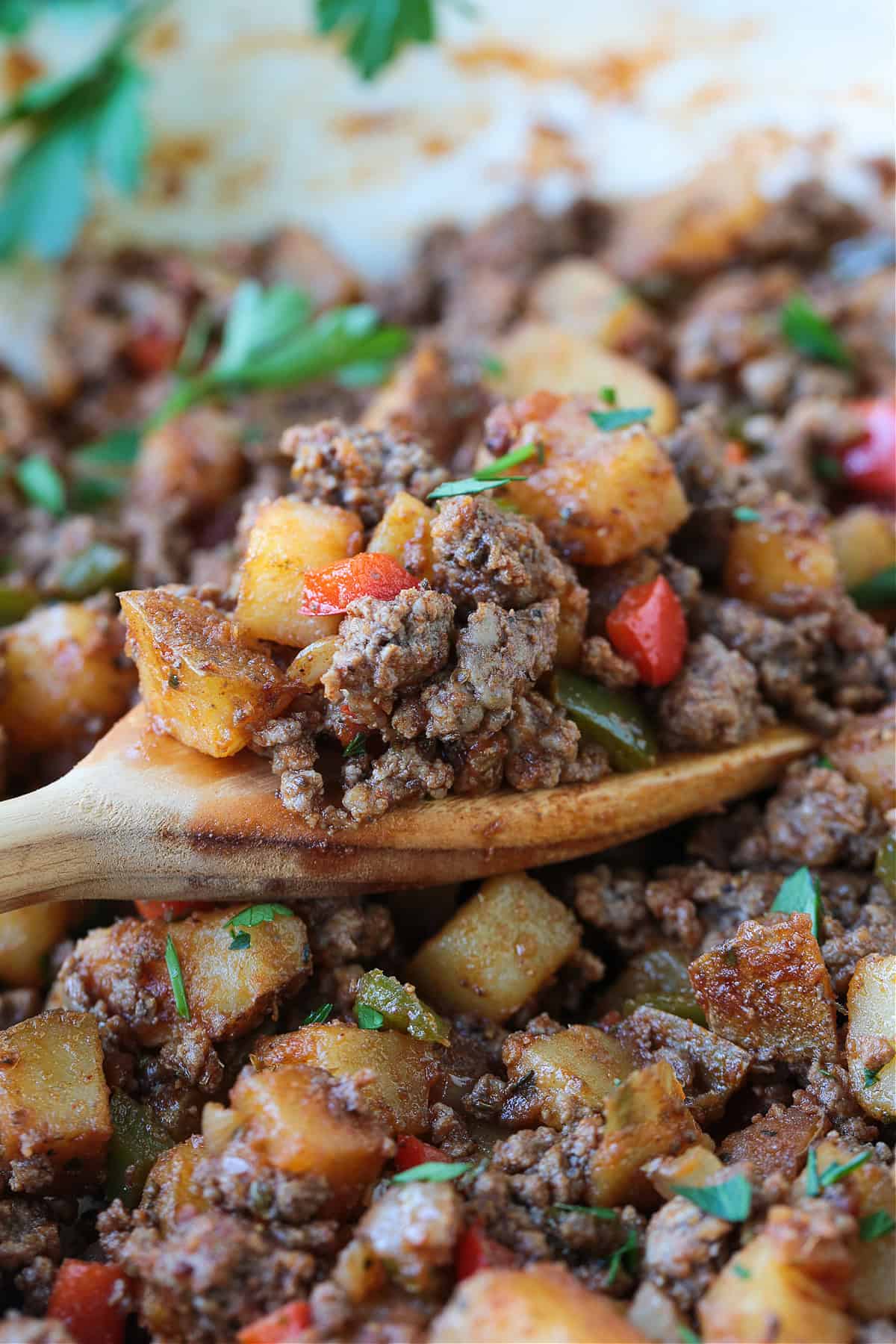 wooden spatula in skillet with ground beef and vegetables