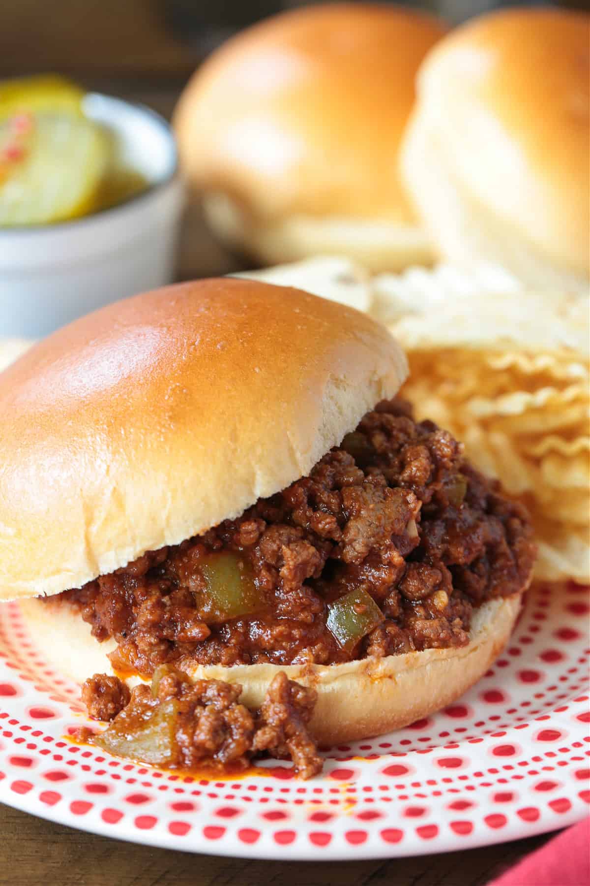 sloppy joe sandwich in red and white plater with chips