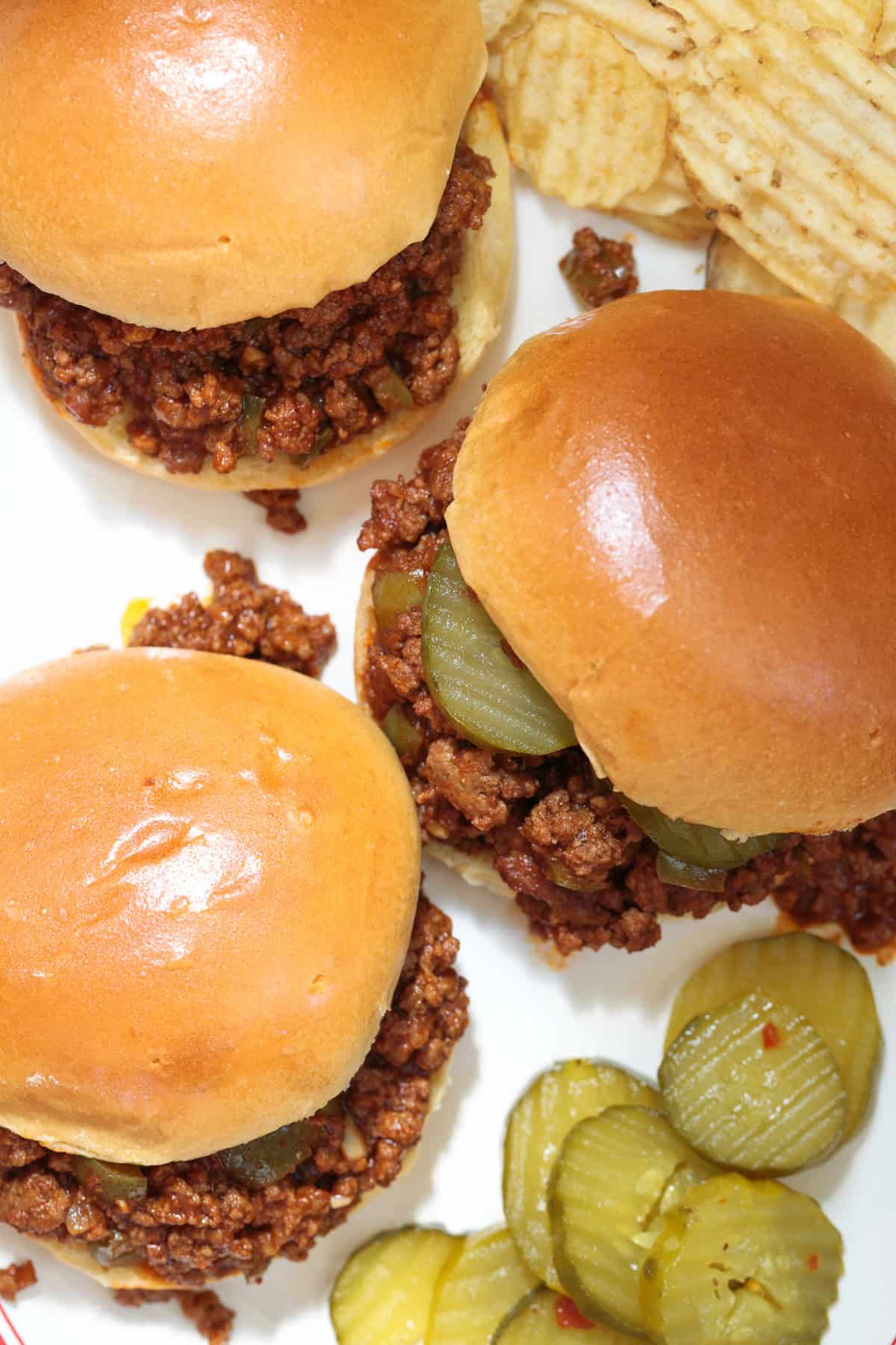 sloppy joe sandwiches on a platter with pickles