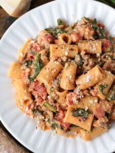 rigatoni with sausage in a pink cream sauce on a white plate