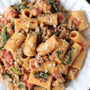 pasta with sausage and spinach on white plate