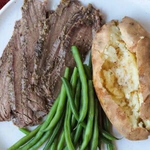 steak, green beans and baked potato on plate