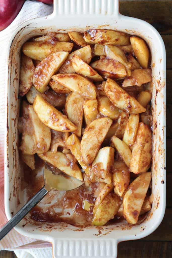 baked apples in baking dish with spoon