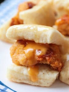 close up of mini chicken sliders with sauce