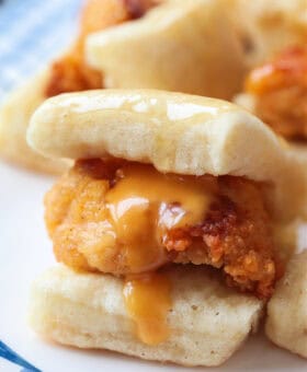 close up of mini chicken sliders with sauce