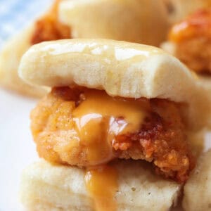 close up of mini chicken sliders with sauce