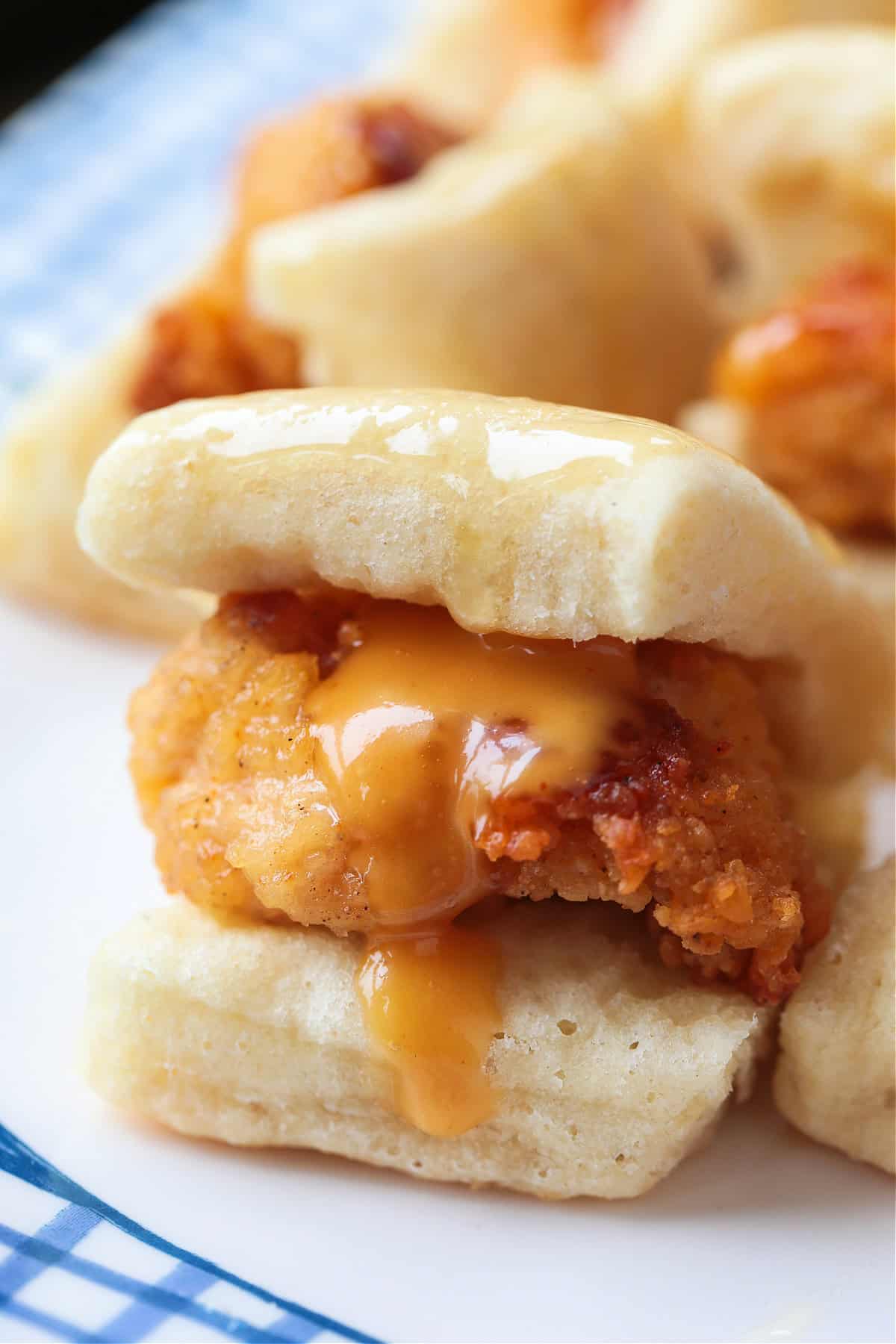 close up of mini chicken sliders with sauce