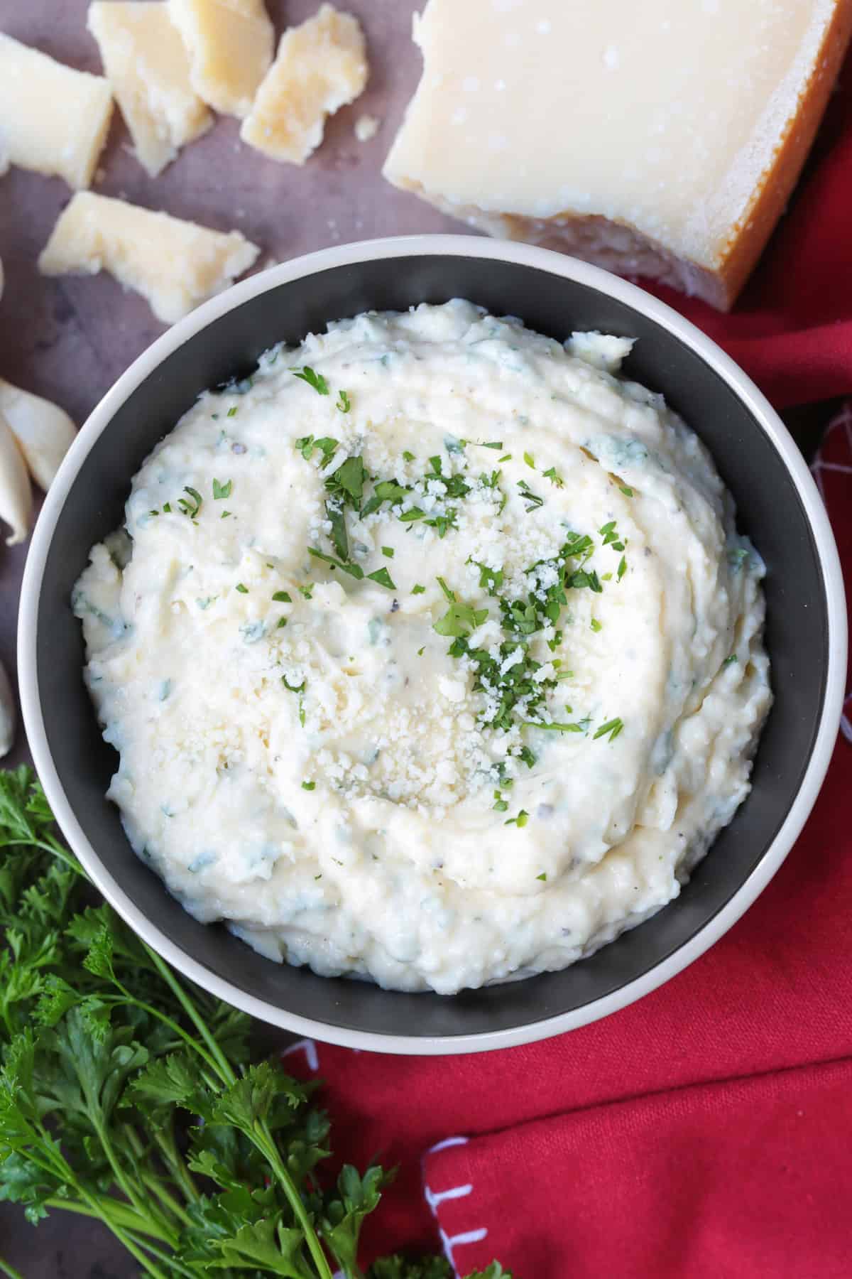 garlic parmesan sauce in black bowl with napkin and parsley