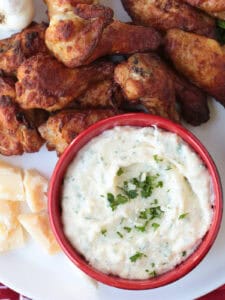 chicken wings on platter with creamy sauce for dipping