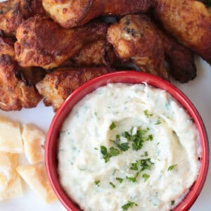 chicken wings on platter with creamy sauce for dipping