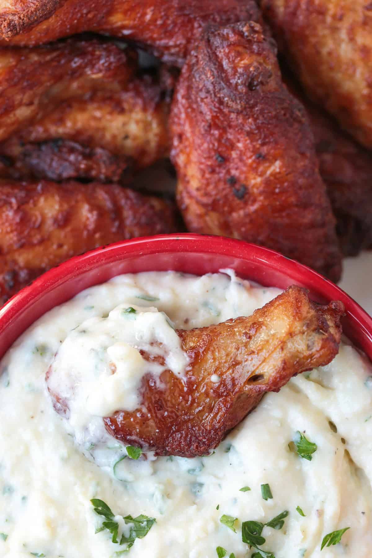 chicken wing dipped into creamy sauce