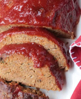 sliced meatloaf on a platter with red napkin