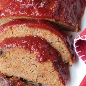 sliced meatloaf on a platter with red napkin