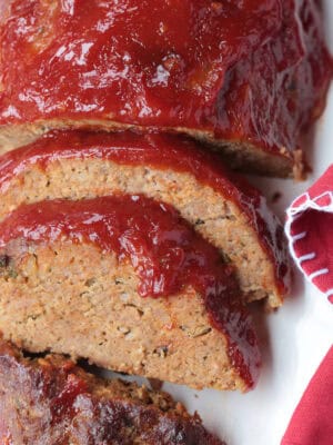 sliced meatloaf on a platter with red napkin