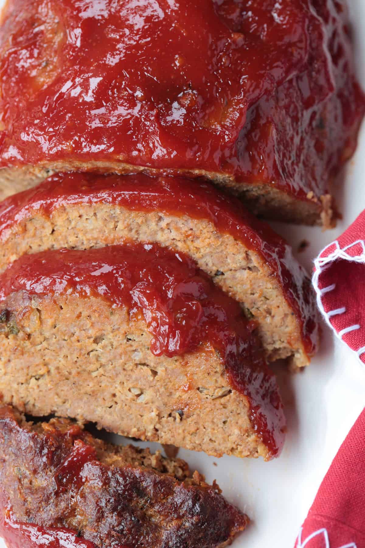 sliced meatloaf on a platter with red napkin