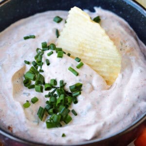 potato chip dipping into bowl of dip